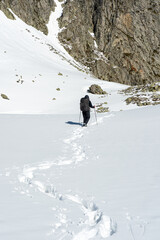 One person walking with snowy slope while leaving footpath behind on a  hike in the French Alps near Grenoble