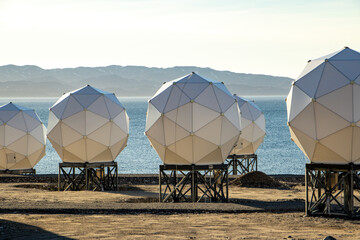 Geodesic domes by the sea, satellite communication station in an Arctic landscape, Greenland