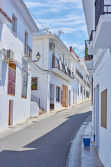 Obraz premium Street, mountain and travel with old city, holiday and adventure with vacation, Frigiliana and Andalusia. Spain, empty and buildings with architecture, outdoor and road with journey, sky and holiday