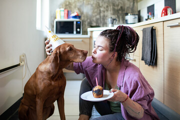 Woman celebrating dog birthday in the kitchen