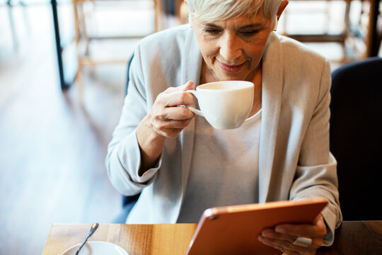 Elderly professional woman enjoying coffee in a cafe