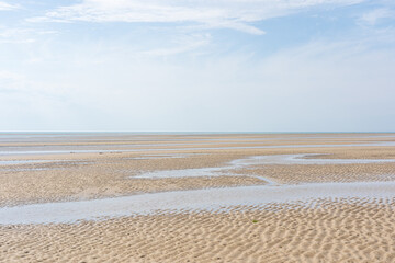 Wide panoramic view of  a beach on a sunny bright day in the Baie de Somme natural reserve in northern France by the English channel