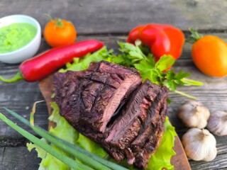 Lamb steak surrounded by vegetables and lettuce and horseradish. High-quality photo