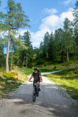 Fototapeta premium Älterer Mann fährt mit seinem E Mountainbike durch die Bikewelt Karnische Alpen in Nassfeld in Kärnten Österreich