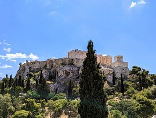 Panoramic view over the Acropolis and the temple of the Parthenon with a tall green cypress tree in the foreground in Athens, Greece, Europe.