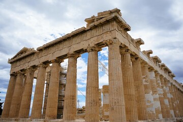 Columns and marble remains of the mighty Parthenon on the hill of the Acropolis in Athens, sacred temples of the goddess Athena and tutelary goddess of the city - sightseeing and vacation in Greece