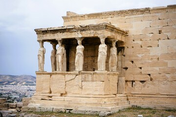 Obraz premium Athens, Greece, 08.26.2024: Famous marble statutes on The Porch of the Caryatids in the Erechtheum on the hill of the Acropolis of Athens in Greece, Sightseeing and vacation in Griechenland