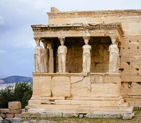 Obraz premium Athens, Greece, 08.26.2024: Famous marble statutes on The Porch of the Caryatids in the Erechtheum on the hill of the Acropolis of Athens in Greece, Sightseeing and vacation in Griechenland