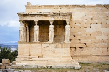 Obraz premium Athens, Greece, 08.26.2024: Famous marble statutes on The Porch of the Caryatids in the Erechtheum on the hill of the Acropolis of Athens in Greece, Sightseeing and vacation in Griechenland