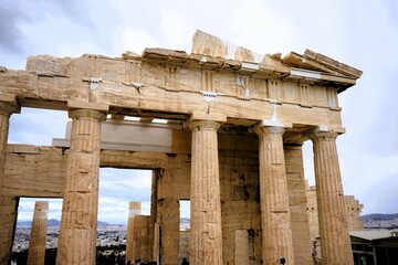 Obraz premium Columns and marble remains of the mighty Parthenon on the hill of the Acropolis in Athens, sacred temples of the goddess Athena and tutelary goddess of the city - sightseeing and vacation in Greece