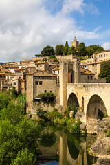Fototapeta premium Village médiéval de Besalú en Espagne dominé par château comtal depuis le pont fortifié sur le fleuve Fluvià