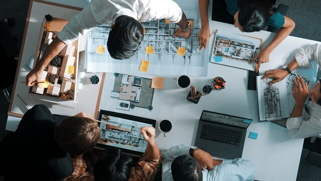 Top aerial view of project manager or civil engineer writing at blueprint and planning building design. Aerial view of architect working together at meeting table with document placed. Alimentation.