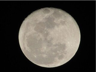 A beautiful photo of the full moon on a dark night in a big city