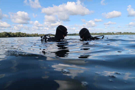 Scuba Divers on the surface of a lake
