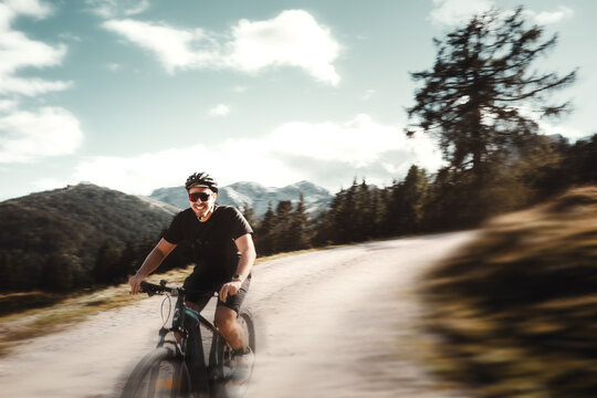 Mann mit Bart und kurzer Kleidung mit Fahrradhelm f&auml;hrt mit seinem Mountainbike durch die Bikewelt Karnische Alpen in Nassfeld in K&auml;rnten &Ouml;sterreich