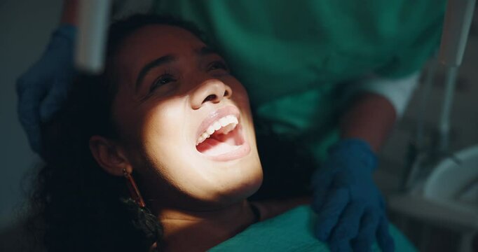 Happy woman, teeth and dentist with light for dental care, hygiene or tooth whitening at private practice. Young, female person and smile with orthodontist for oral, mouth and gum cleaning at clinic