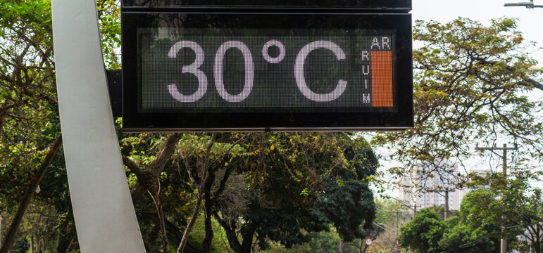 Street weather station sign with temperature showing 30 degrees heat and poor air quality in S&atilde;o Paulo.