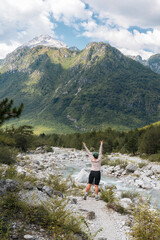 Naklejka premium A hiker girl with a backpack in the mountains of Albania. Trekking in the Prokletie Mountains.