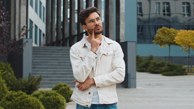What. Why. Surprised frustrated Indian man raising hands asking reason of failure, demonstrating disbelief irritation by troubles outdoors. Confused Arabian Hindu guy standing in urban city street