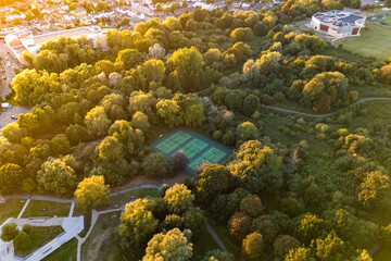 Aerial drone view of Tennis courts in the middle of a public park during sunset time