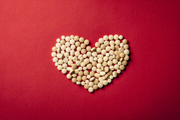 White heart pills frame on a red background. Banner template for advertising vitamins, medicines, healthy lifestyle, microelements  with copyspace