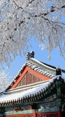 Snow-covered ancient Chinese architecture with traditional roof design under winter branches in serene winter landscape