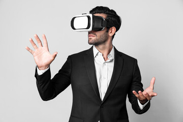 Professional business man holding something while using VR glasses to enter metaverse. Project manager looking at data analysis while wearing suit and virtual reality goggles. Innovation. Deviation.