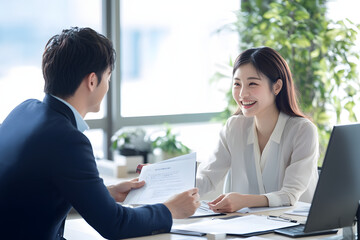 Young Japanese man and woman in casual working together at an office desk