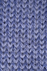 macro texture of purple crocheted sweater as a background, close-up of purple crocheted front surface, woolen texture of alpaca wool crocheted  