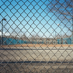 Fototapeta premium Large Barren Playground Surrounded by a Chain-Link Fence