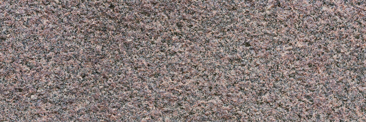 Granite texture. Natural pink granite with a grainy pattern. Stone background. Solid rough surface of rock. Durable construction and decoration material. Close-up.