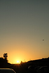 plane flying into sunset