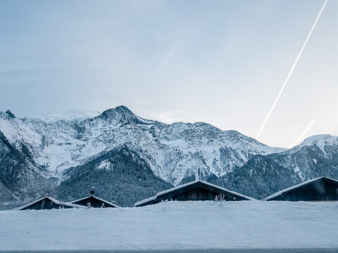 Snow-covered rooftops in Chamonix, France with majestic mountains during winter on December 21, 2017