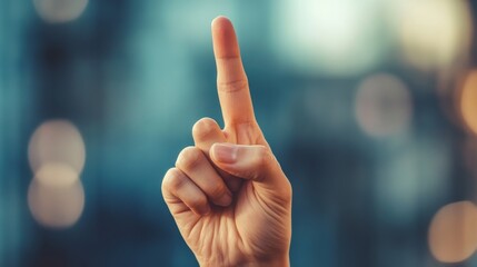 Hand showing index finger against blurred blue background
