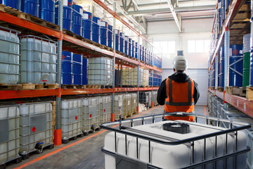 Man standing in fuel warehouse. Storage chemical products. Warehouse with barrels with fuel....