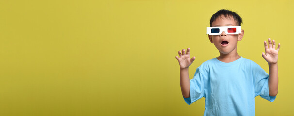 Asian boy with surprised expression wearing 3d glasses, Watching movie isolated on yellow background. Watching movie and cinema concept. Banner design