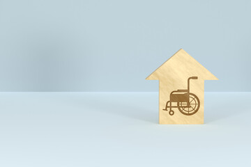 Featured image of a 3D house-shaped wooden block with a wheelchair silhouette
