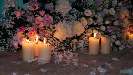 Lighted candles on the floor with a floral arrangement of roses