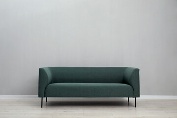 Comfortable sofa near light grey wall indoors, space for text