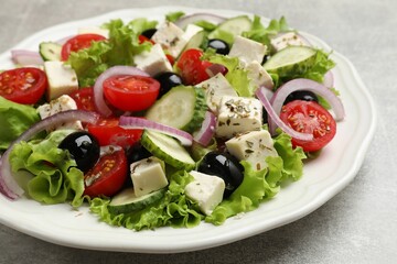 Delicious salad with feta cheese on gray textured table, closeup