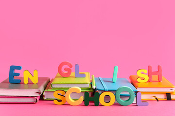 Different notebooks with text ENGLISH SCHOOL on pink background
