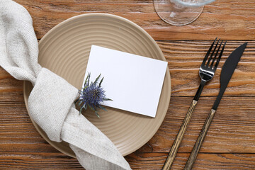 Stylish modern table setting with card on brown wooden background