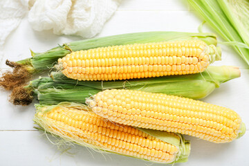 Fresh corn cobs on white table