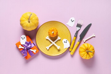 Festive table setting for Halloween celebration with gift box, pumpkins and paper ghosts on purple background