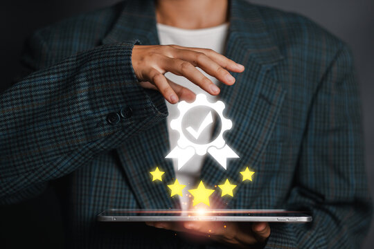 A person holding a tablet with a digital certification badge and stars, symbolizing quality assurance, standards, and excellence.