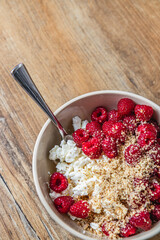 Cottage cheese with fresh raspberries, sliced almonds, and maple syrup