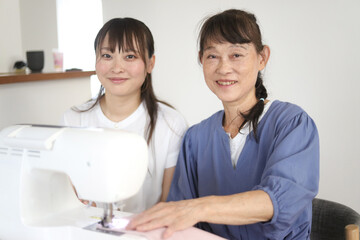 Obraz premium ミシンを使う親子