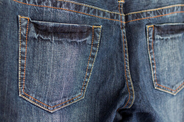 Close-up of back pockets on dark blue jeans