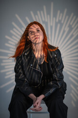 Portrait of a beautiful young red-haired girl in a studio.