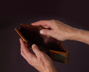 Male hands hold open an old empty wallet